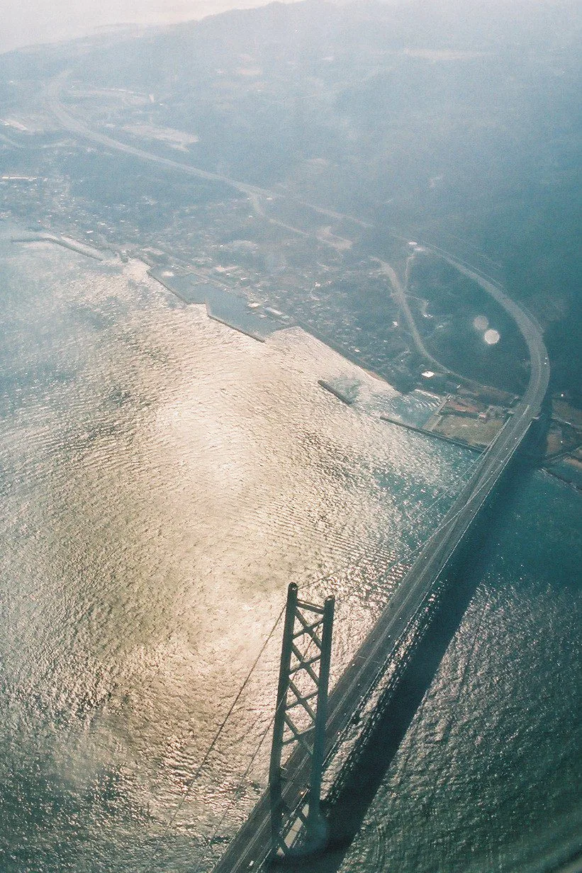 Runner crossing a Kobe harbor bridge at dawn