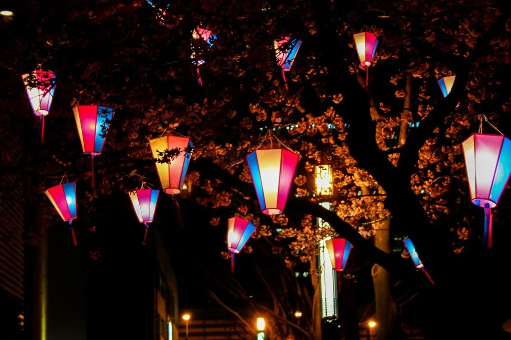 Warm lanterns glowing over a Japanese street at night
